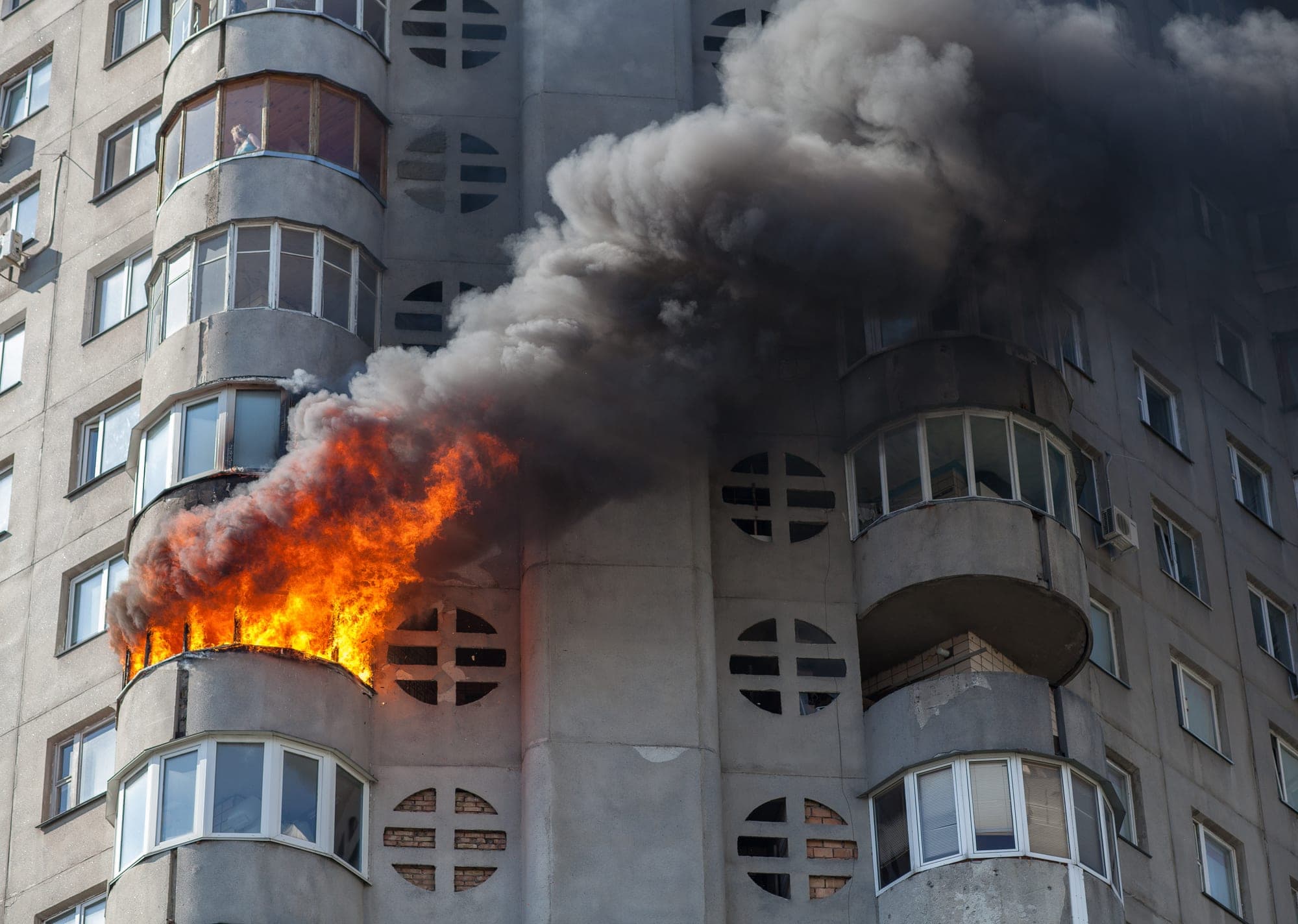 Apartment building balcony fire with heavy black smoke